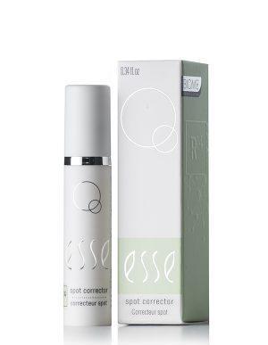 A bottle of Spot Corrector stands beside its box, both featuring a minimalist white and light green design with subtle circles and text showing the product name and function.