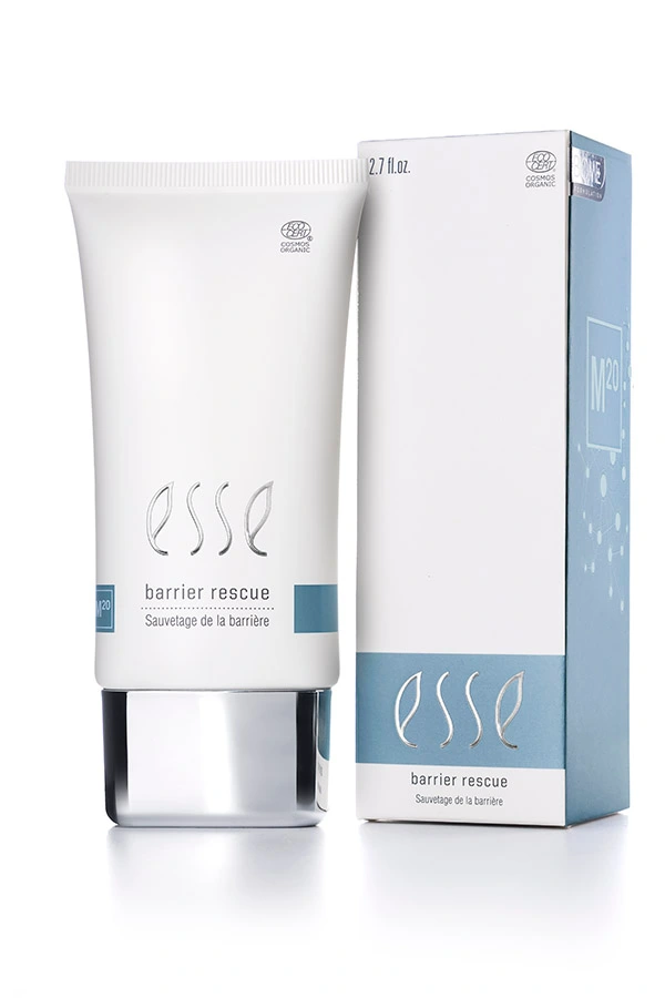 A white tube of Esse Barrier Rescue stands beside its coordinating box, both displaying minimalist blue and gray accents with English and French text.